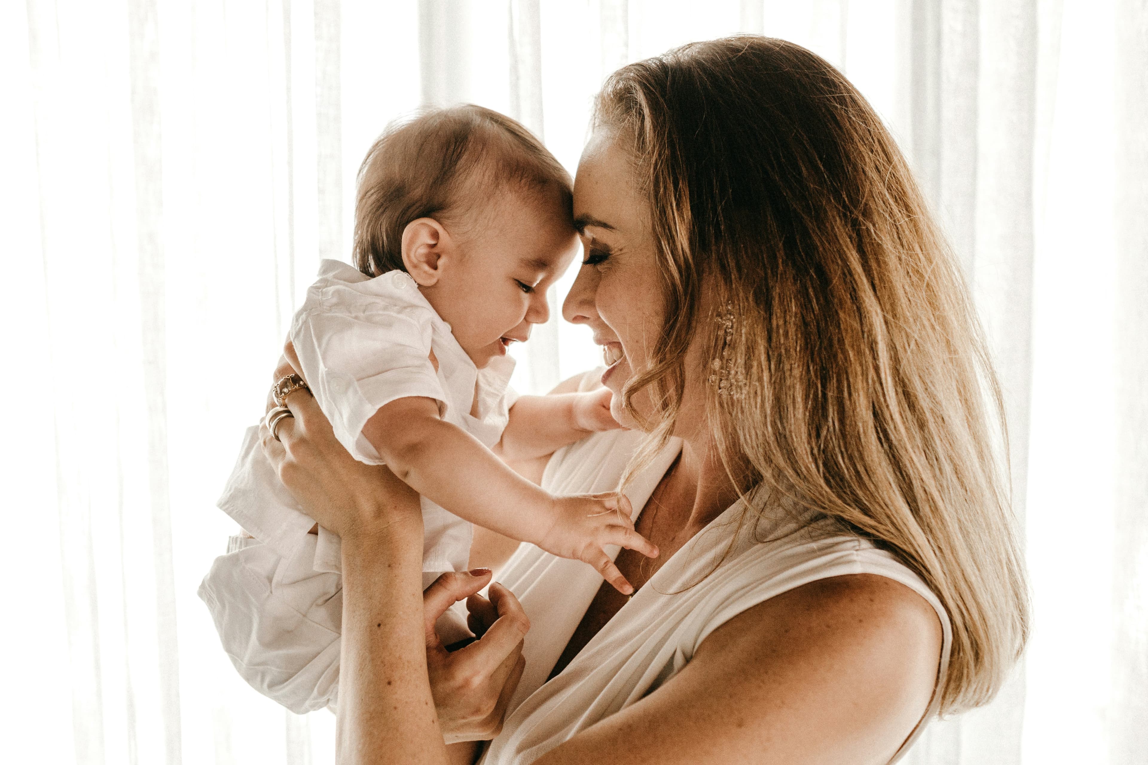 A parent holding their baby, both smiling