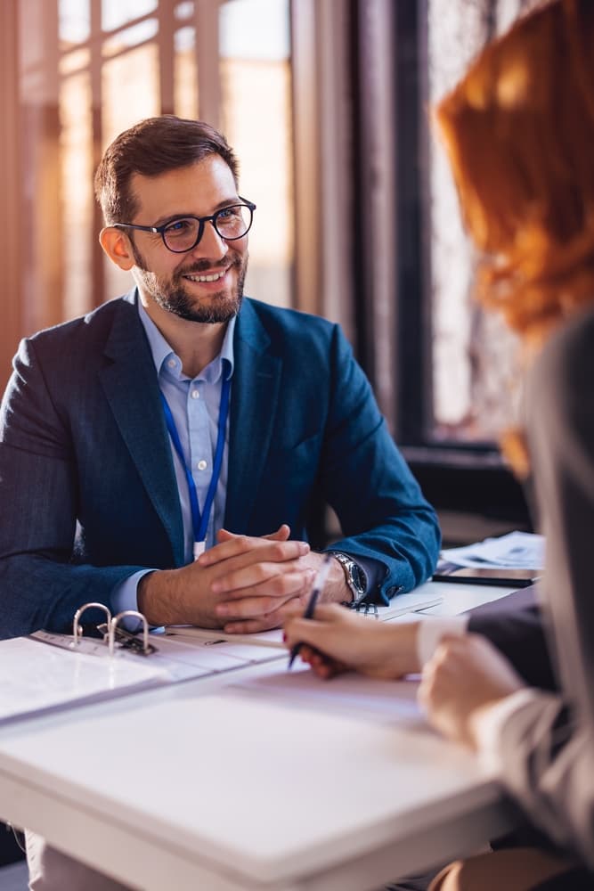 The insurance agent finalizes the agreement, and both client and agent sign the contract, sealing the deal with a handshake.