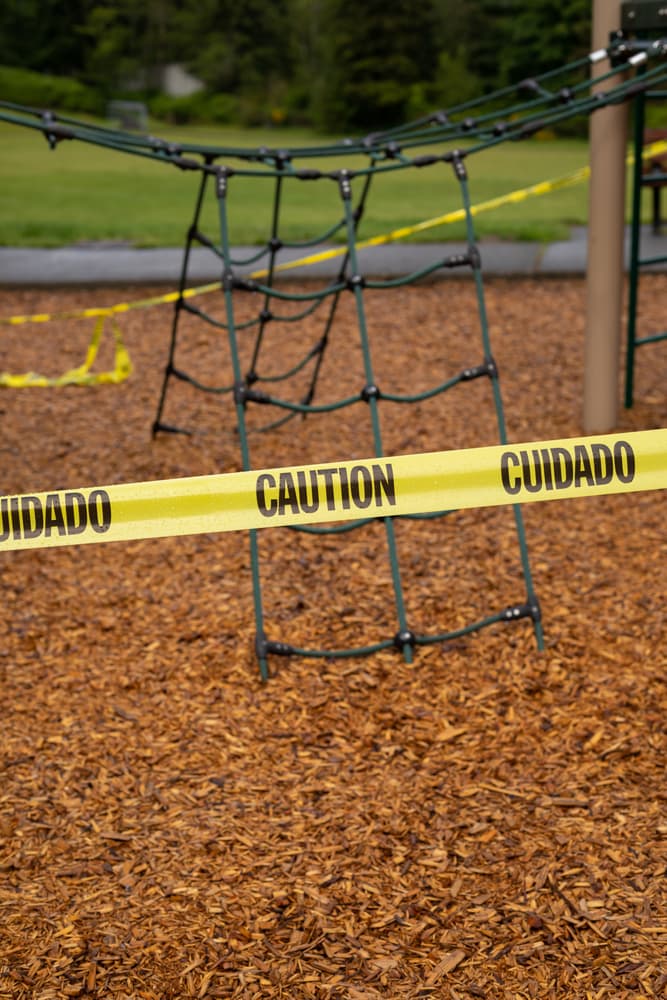 Playground restricted with caution tape due to COVID-19 precautions, ensuring public safety and health measures are observed.