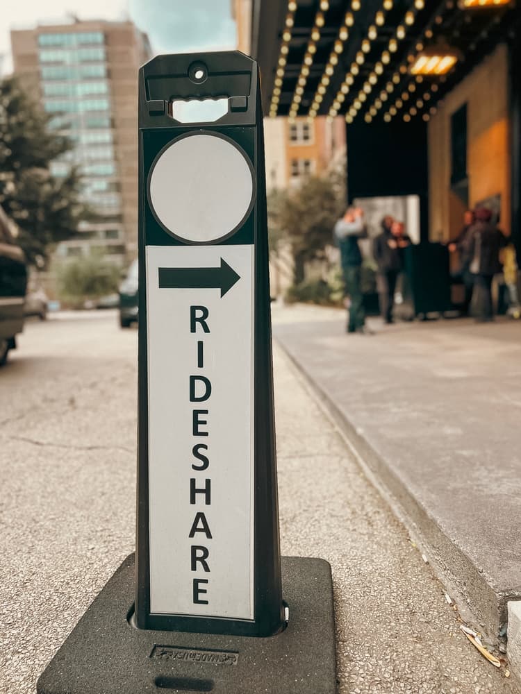Clear rideshare pickup signage with directional arrow indicating designated passenger drop-off/pick-up area for drivers. Easy and efficient transportation.