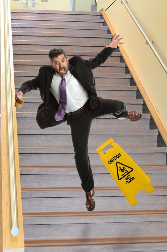 Experienced Hispanic businessman in a stumble on stairs, highlighting a moment of unexpected imbalance.