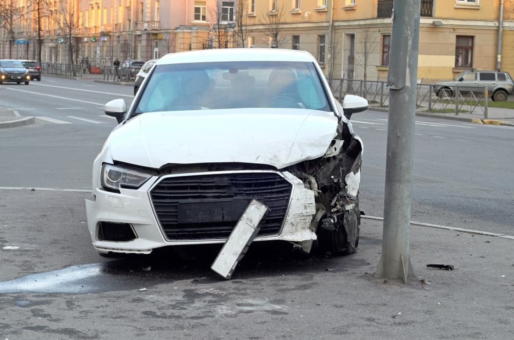 The front of a car damaged in an accident involving a pole. Car insurance claim.