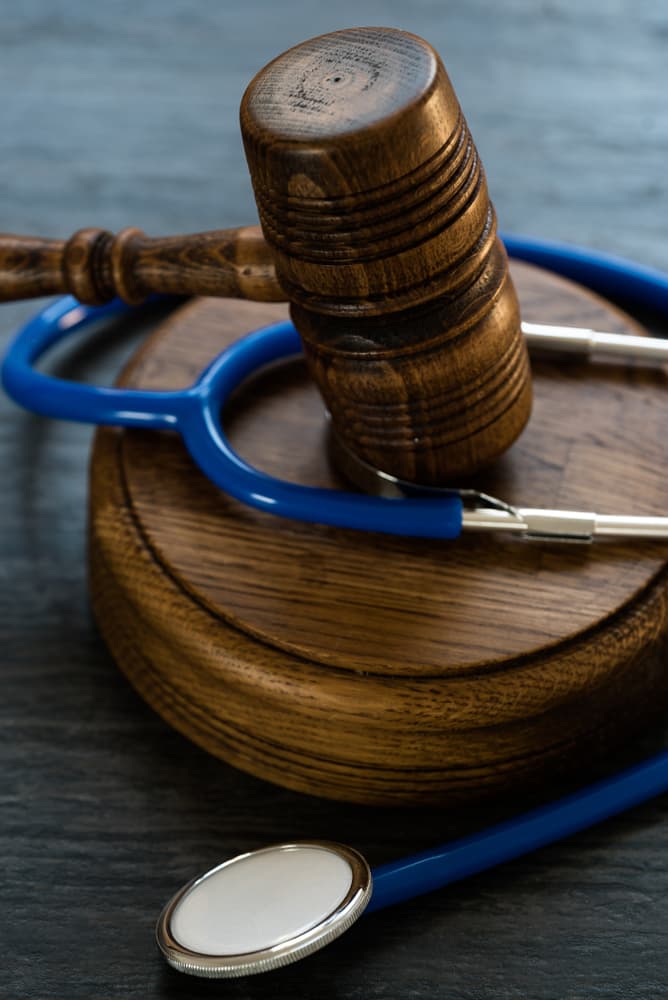 A wooden gavel and a blue stethoscope on a table