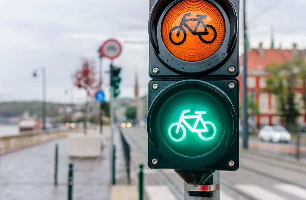 Cyclist traffic signals with a cityscape in the background.