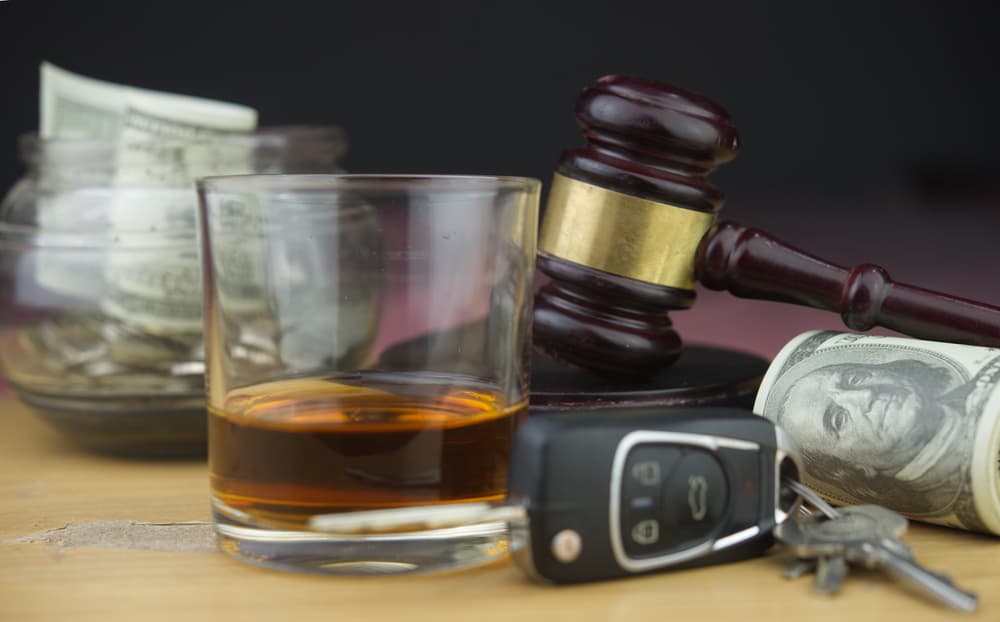 Drunk driving concept: judge's gavel, whiskey glass, and car key symbolizing legal consequences of impaired driving.