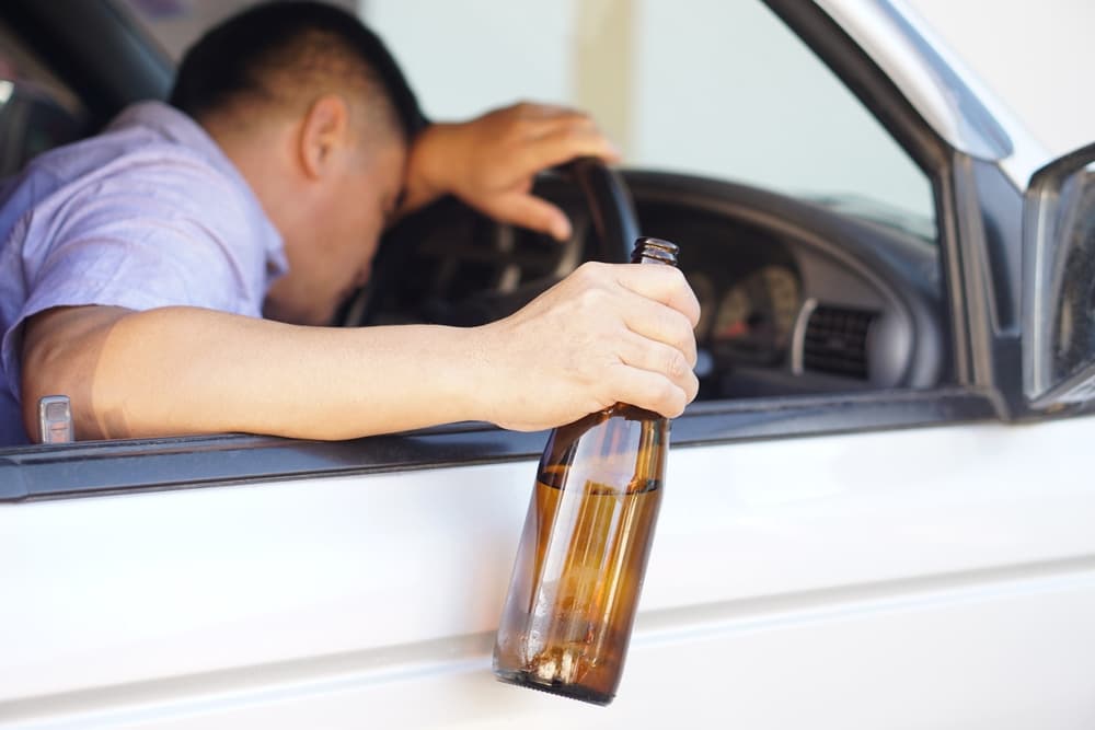 Drunk man holds beer bottle in car. Concept , Campaign for don't drive, don't drink alcohol that can cause car accident and illegal. Dangerous driving when drunk.
