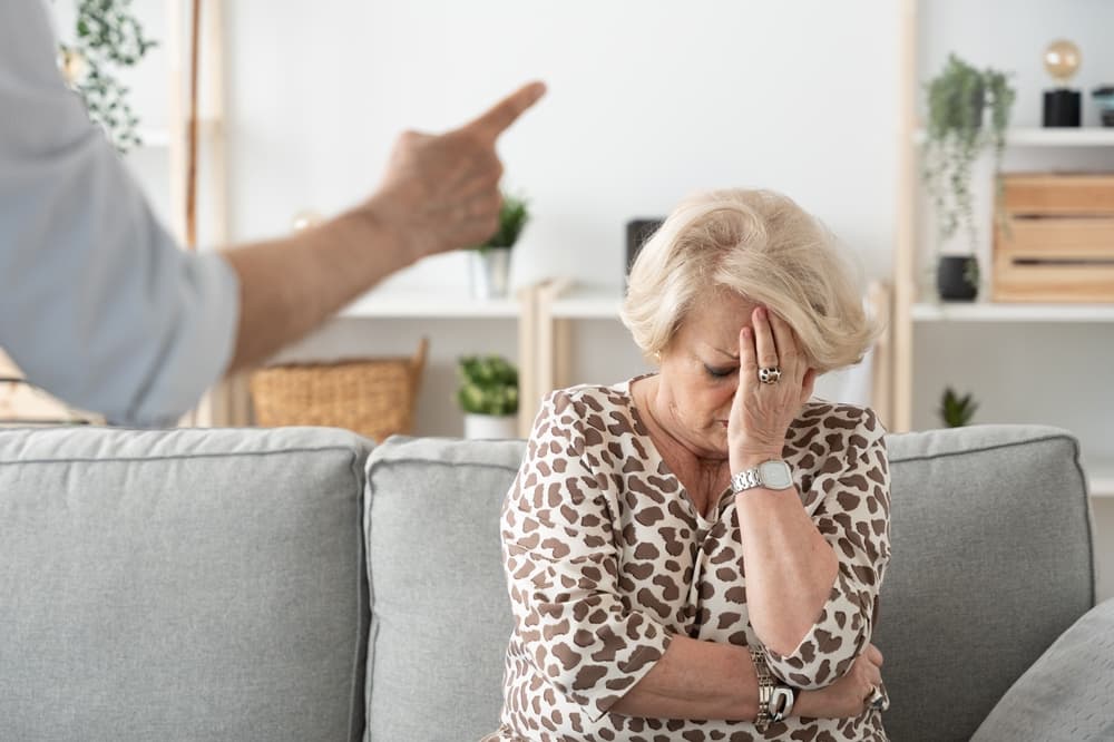 An unidentified man is seen intimidating an elderly woman in a nursing home setting.