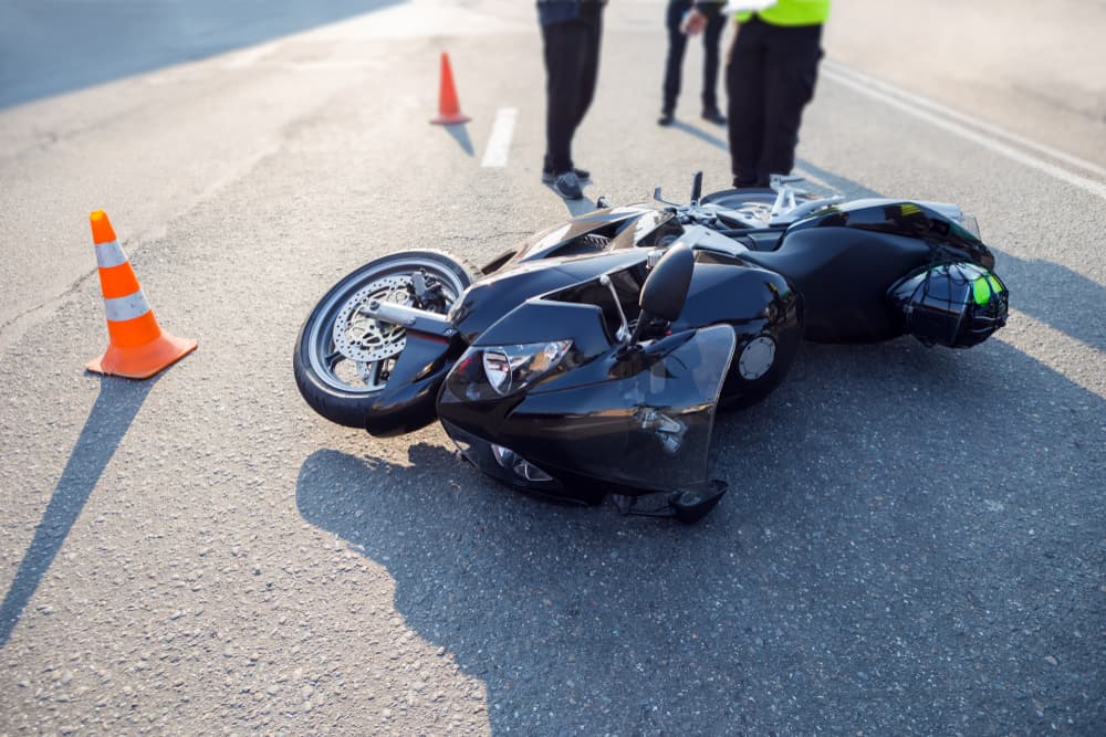 Damaged motorcycle lying on the road at the scene of an accident.