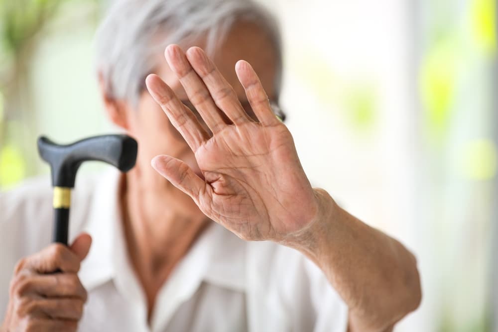 Senior woman raising hand in a stop gesture—symbolizing a stand against elder abuse, mistreatment, and bullying. Protect the elderly from harm.