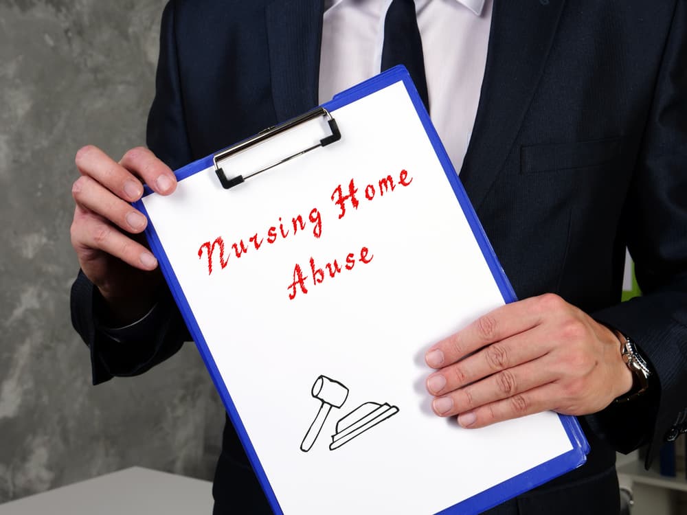Legal concept of nursing home abuse displayed with a sign on a document.