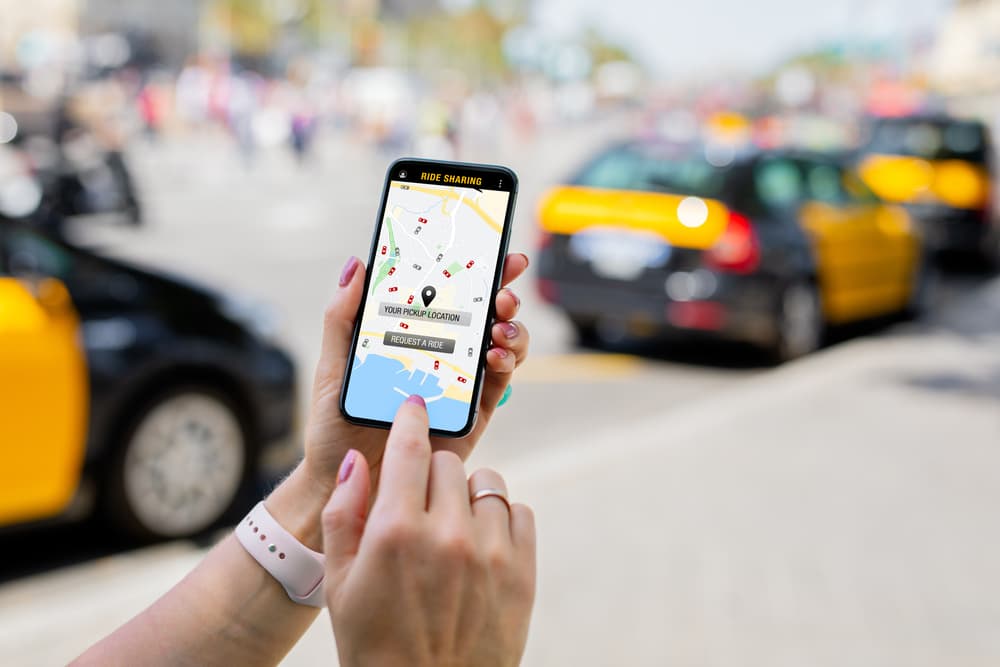 Individual navigating a rideshare app on their smartphone.