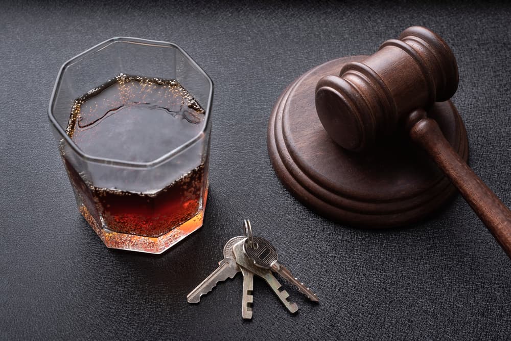 Gavel and liquor bottle symbolizing drunk driving. Concept for justice, legal consequences, and the dangers of alcohol-impaired driving.